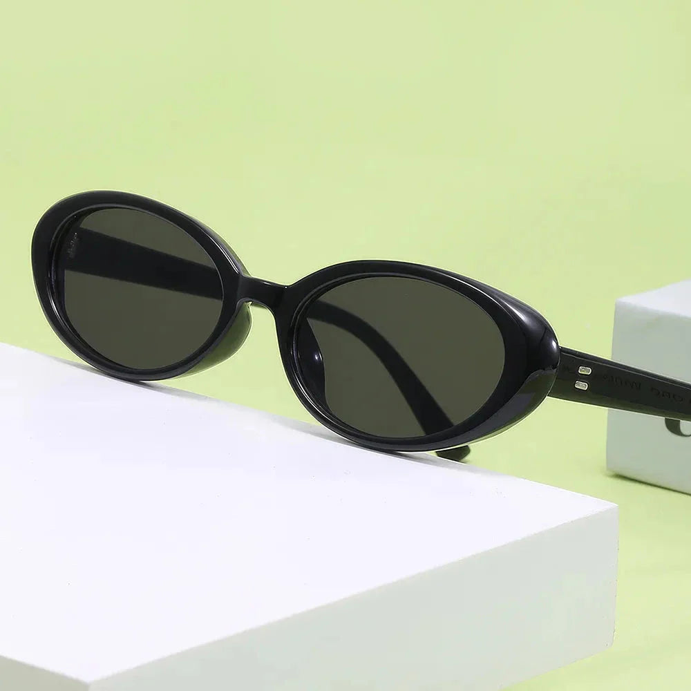Oval-shaped women's sunglasses in a white and grey colour, offering UV protection and a stylish, retro-inspired design.