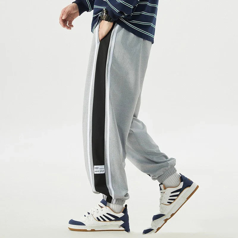 Plus-size men's loose sports trousers with ankle ties, made of premium polyester fabric in classic colours for versatile, comfortable activewear.