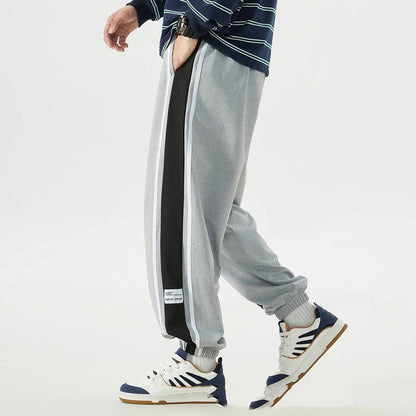 Plus-size men's loose sports trousers with ankle ties, made of premium polyester fabric in classic colours for versatile, comfortable activewear.