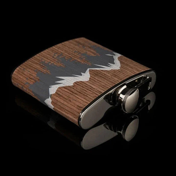 Stylish mountain-themed stainless steel and wood hip flask with optional glasses, perfect for outdoor adventures and social gatherings.