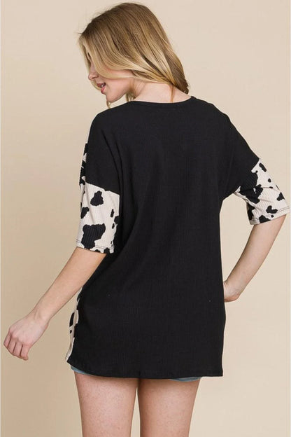 Stylish ribbed tee with playful cow print design, perfect for casual and smart-casual occasions.