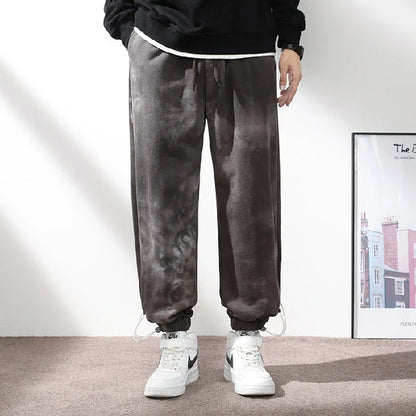Stylish ankle-tied sweatpants in camouflage black, featuring an elasticated waistband, drawstring, and ankle ties for a relaxed yet refined look.