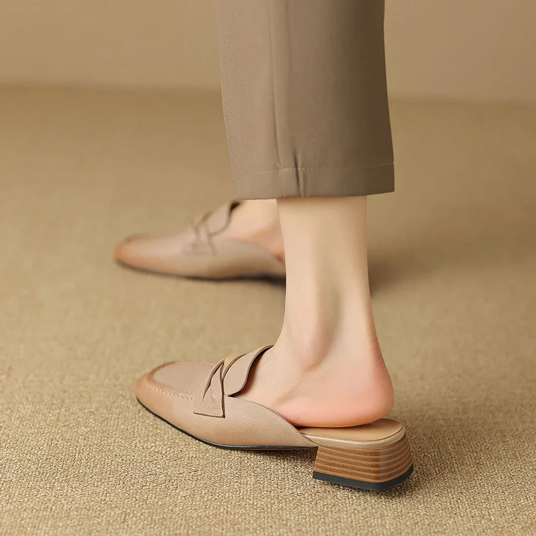 Stylish leather mules in a khaki colour, featuring a low square heel and a sleek, shallow-cut design for a retro-inspired, sophisticated look.