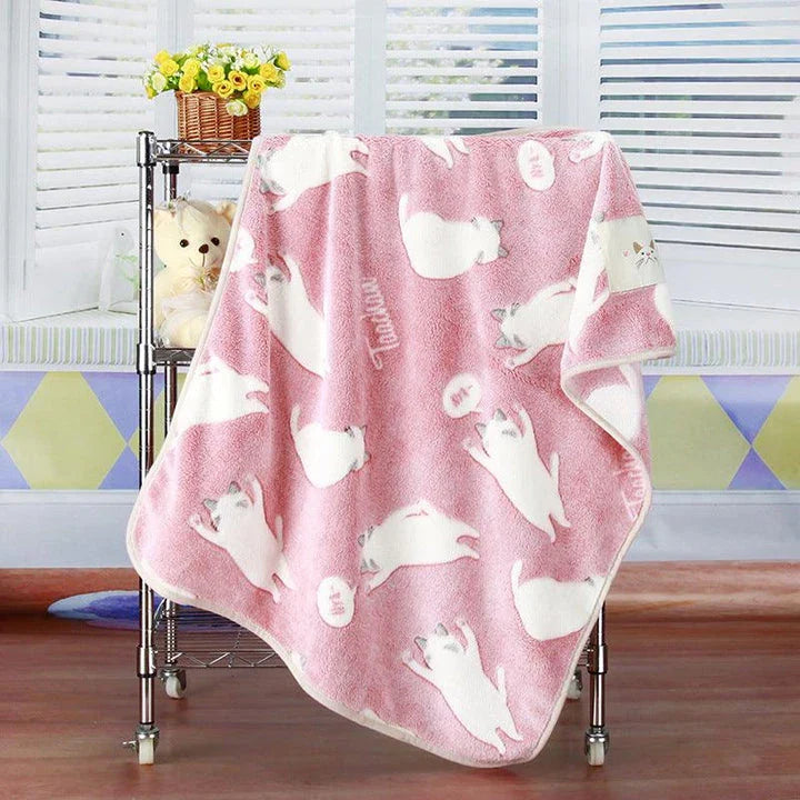 A large, soft, and cosy fleece blanket in a light blue colour, perfect for snuggling up on a bed or sofa