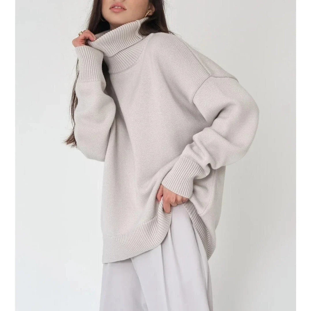 Cosy oversized knitted pullover in blue, featuring a classic turtleneck collar and drop-shoulder silhouette for maximum comfort and style.