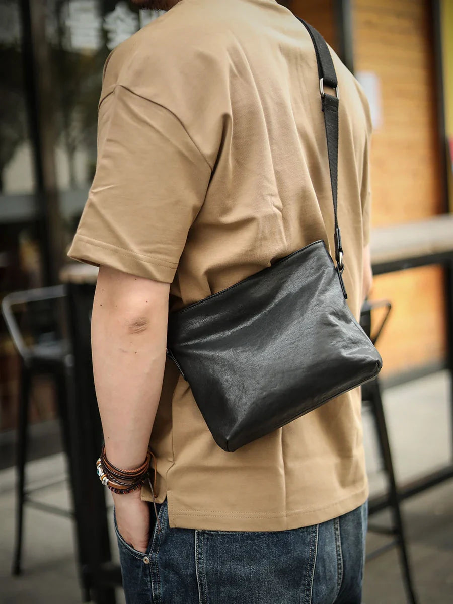 Premium black leather shoulder bag with horizontal zipper closure, featuring a spacious interior and versatile design for the modern British gentleman