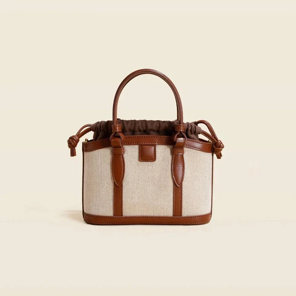 Refined genuine leather women's messenger bag in a stylish, square shape with a convenient string closure and adjustable shoulder strap.
