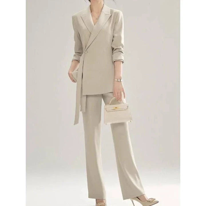 A two-piece vintage-inspired office suit with a long-sleeve blazer and high-waisted trousers, designed for the modern professional woman.