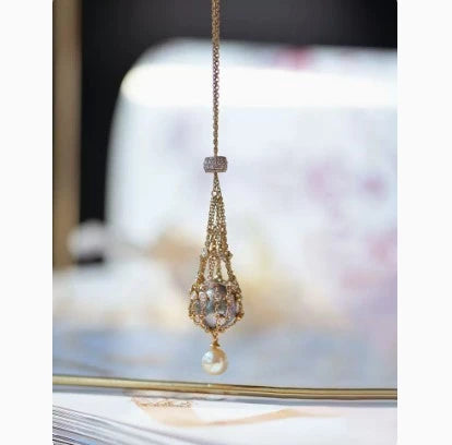 Exquisite 18K gold necklace with a delicate net pocket, inlaid gem, and iridescent shell beads