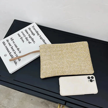 A natural straw-woven clutch with a zipper closure, perfect for summer outings in the UK.
