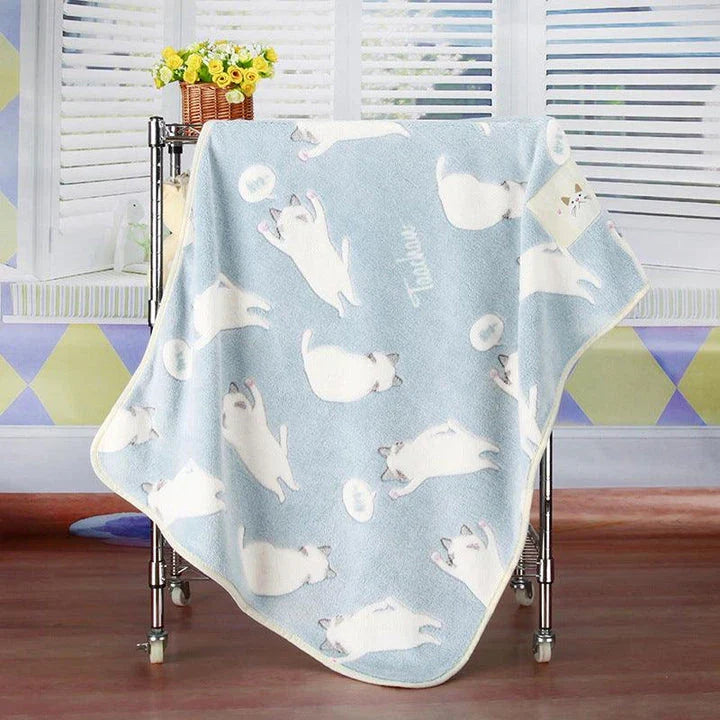 A large, soft, and cosy fleece blanket in a light blue colour, perfect for snuggling up on a bed or sofa