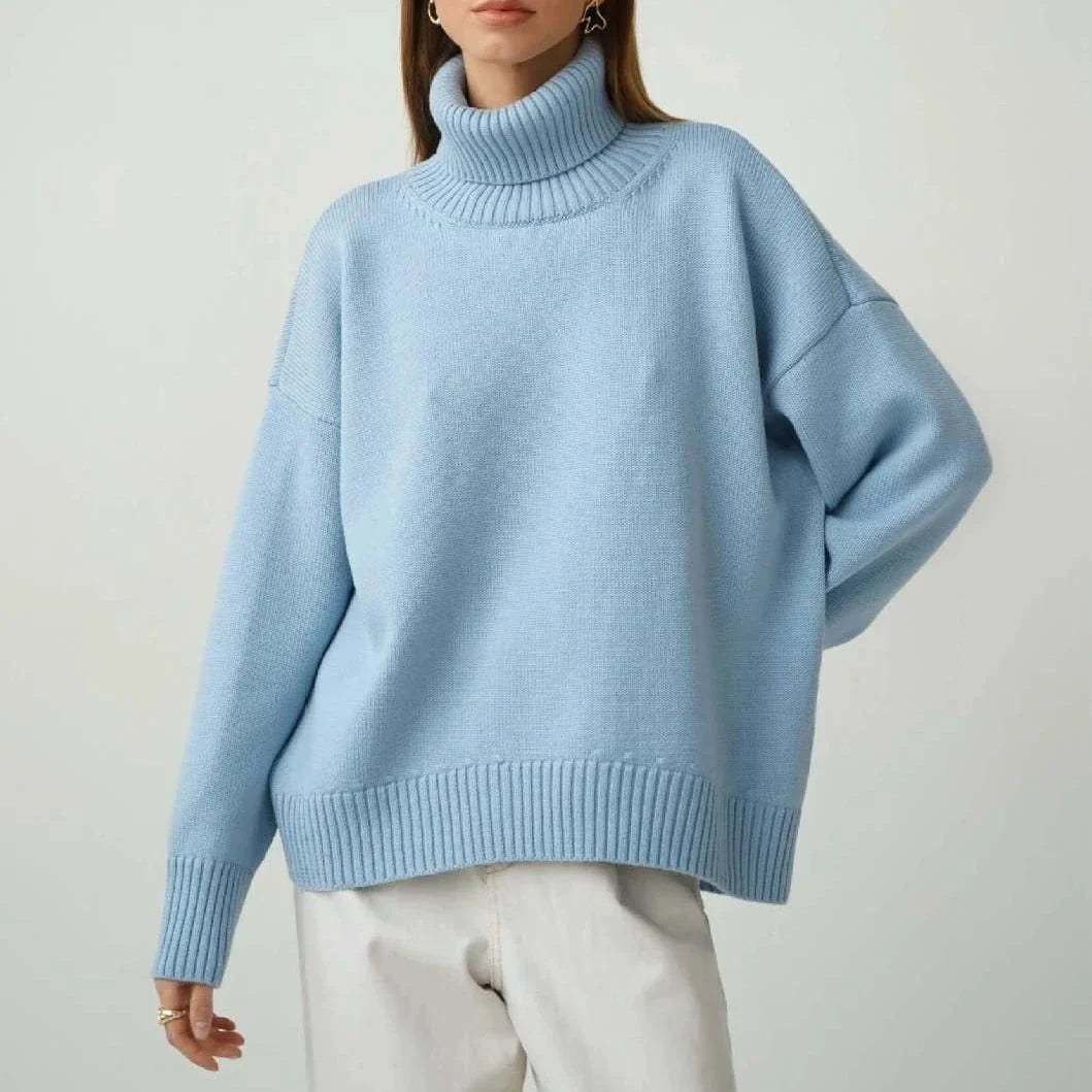 Cosy oversized knitted pullover in blue, featuring a classic turtleneck collar and drop-shoulder silhouette for maximum comfort and style.