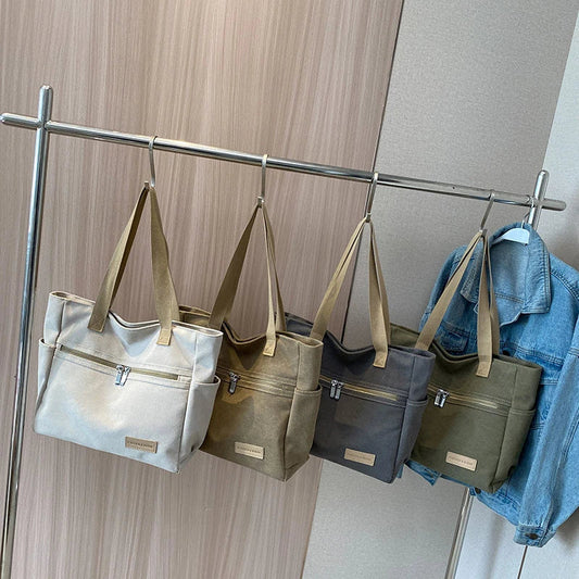 Premium canvas shoulder bag in grey, khaki, and green colours, featuring a stylish and functional design for everyday use.