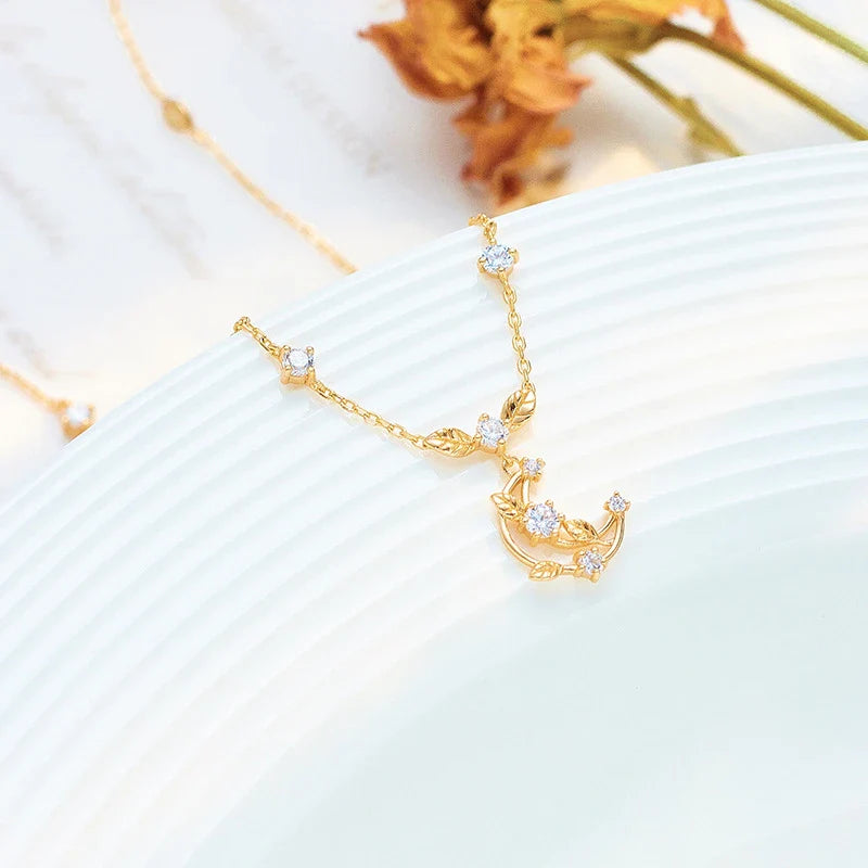 Elegant crescent moon necklace with intricate leaf design in a gleaming gold tone