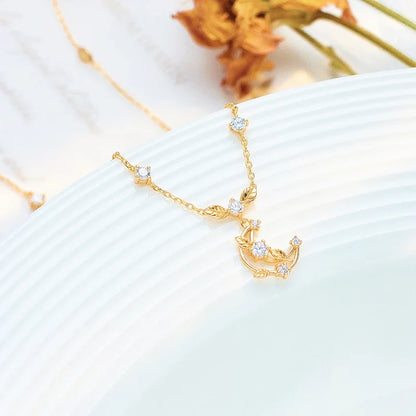 Elegant crescent moon necklace with intricate leaf design in a gleaming gold tone