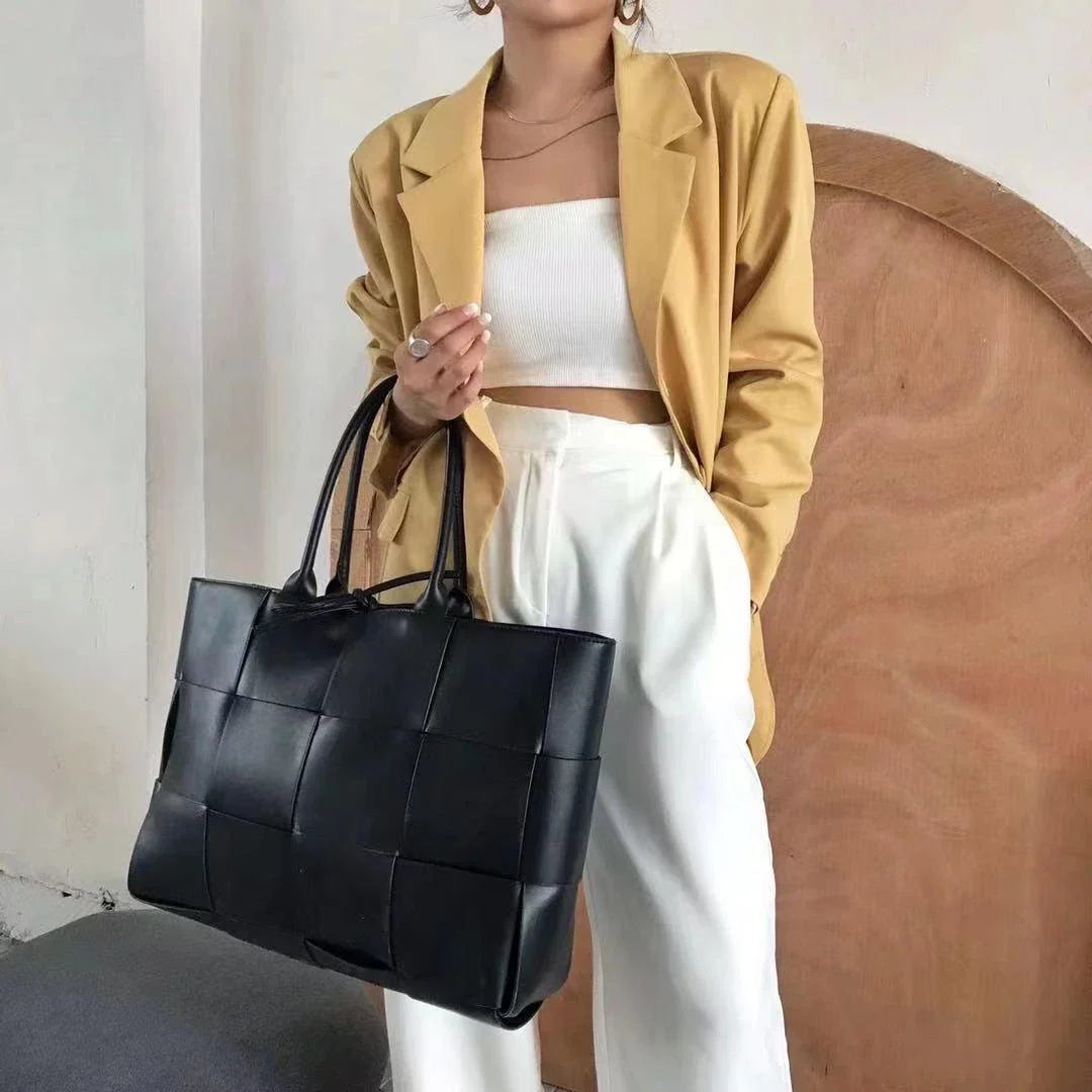 Exquisitely crafted leather tote bag with a timeless woven design, embodying British elegance and quality.