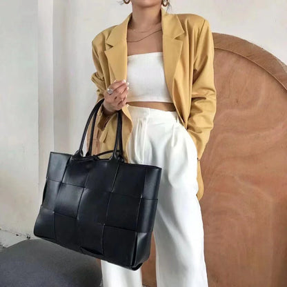 Exquisitely crafted leather tote bag with a timeless woven design, embodying British elegance and quality.