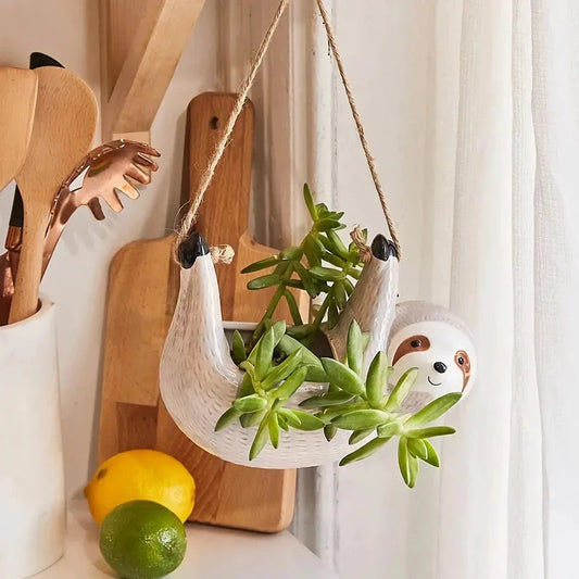 Ceramic hanging planter with a whimsical cartoon animal design, available in grey or yellow, for adding a touch of nature and playfulness to indoor spaces.