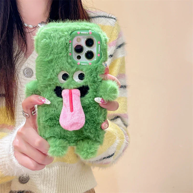 Playful plush phone case with cheeky cartoon monster in pink or green, offering shock-absorbing protection for iPhone models