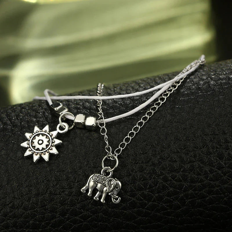 Elegant bohemian-style anklet with star and elephant charms in shimmering gold and silver tones