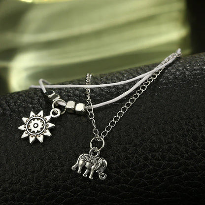 Elegant bohemian-style anklet with star and elephant charms in shimmering gold and silver tones
