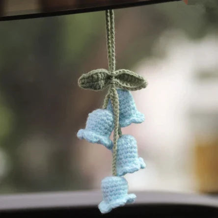 Charming knitted car plant decor with hanging white rope and green and white colour scheme