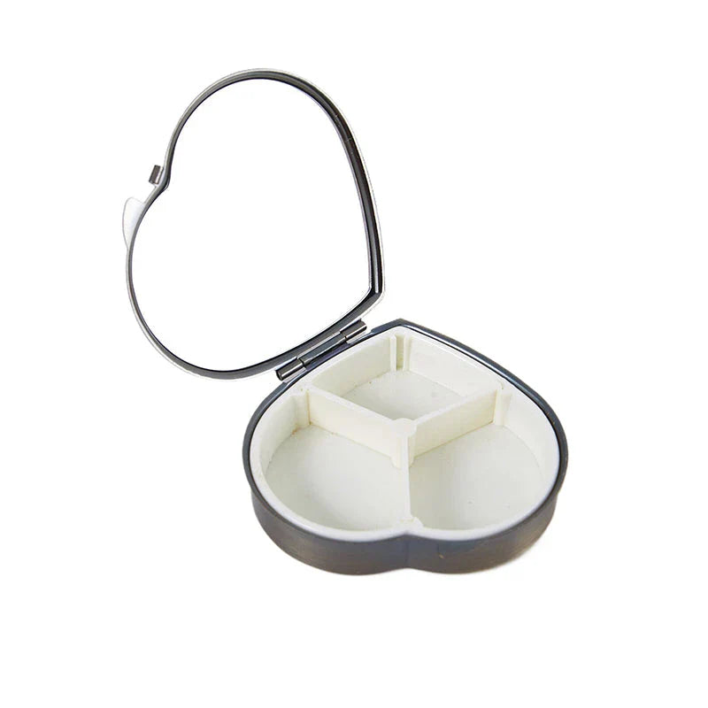 Elegant heart-shaped metal pill box with mirror for organized storage and convenient touch-ups