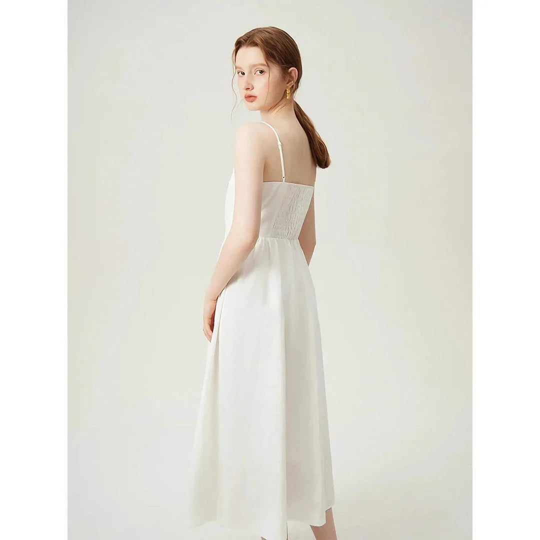 Elegant cotton and linen suspender dress with square collar neckline, A-line silhouette, and mid-calf length for a sophisticated and comfortable summer look.