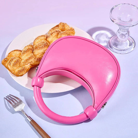 Elegant rose pink leather crescent-shaped crossbody bag with adjustable strap and zipper closure