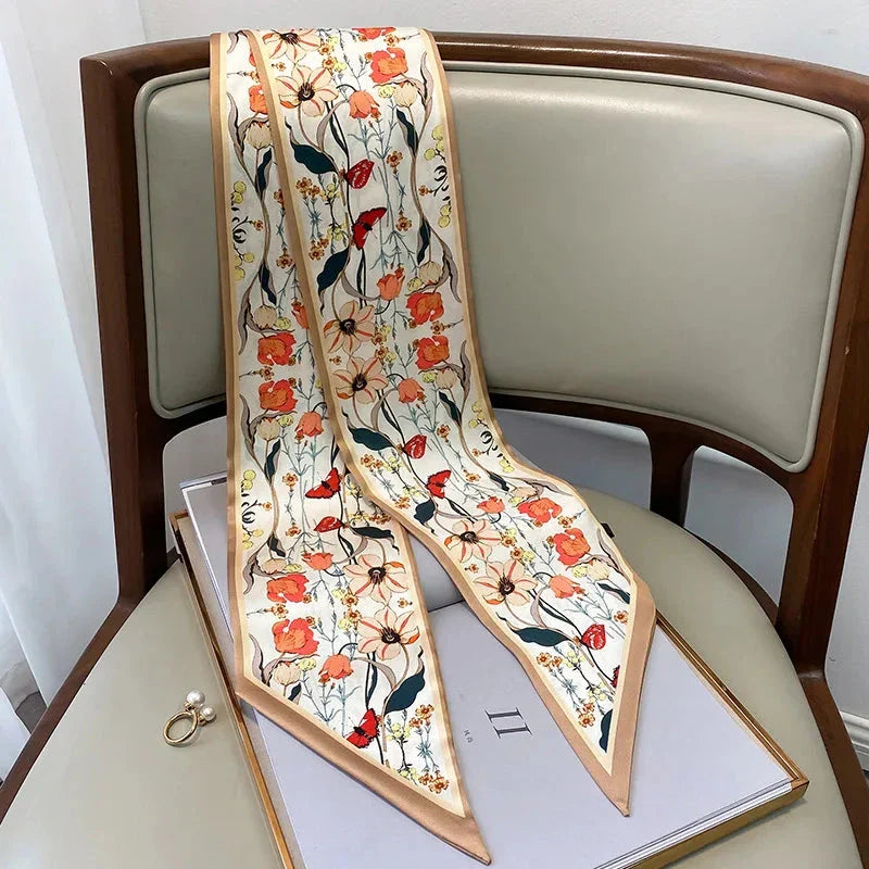 A vibrant floral-patterned silk-feel long scarf that can be worn as a neck accessory, hair tie, or wrist adornment for all occasions.