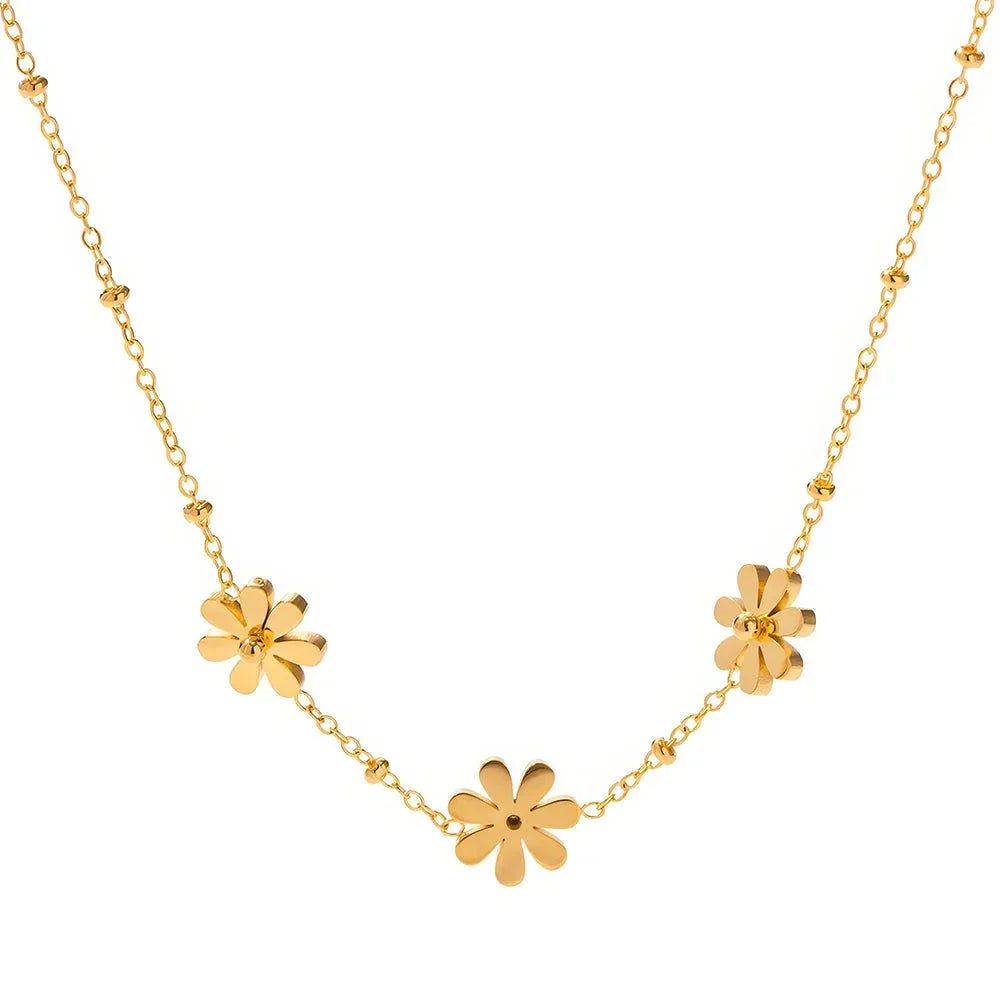 Exquisite 18-carat gold-plated necklace featuring three delicate daisy pendants on a stainless steel chain, embodying timeless British elegance and sophistication.
