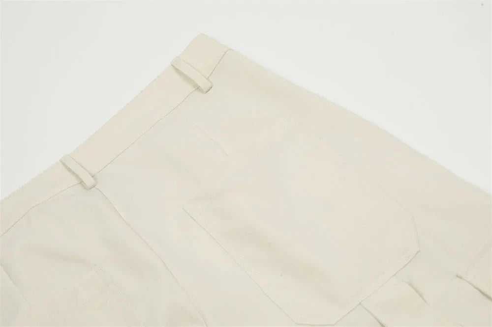 Stylish black pleated overalls with ribbon pockets, a versatile and refined menswear piece.