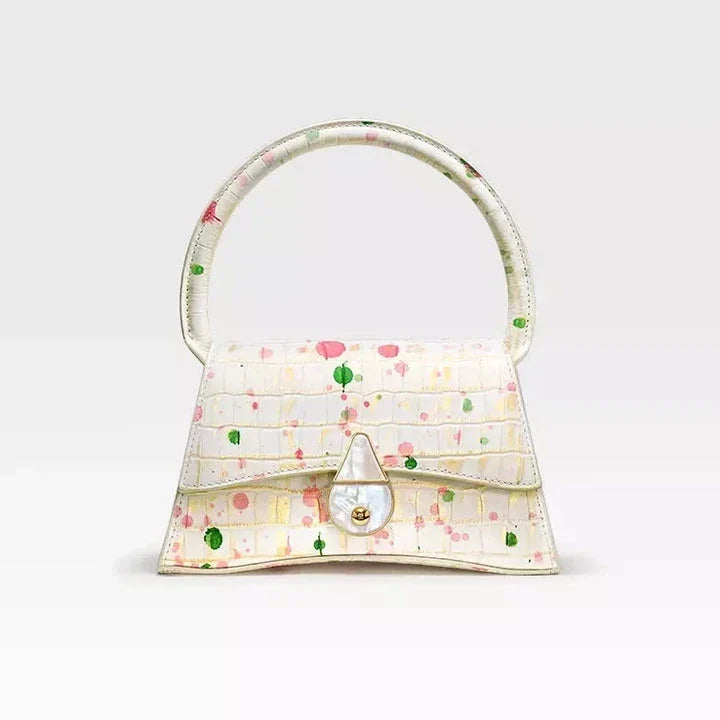 A stylish half-moon shaped genuine leather handbag with a decorative lock, showcasing premium British craftsmanship and timeless elegance.