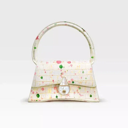 A stylish half-moon shaped genuine leather handbag with a decorative lock, showcasing premium British craftsmanship and timeless elegance.