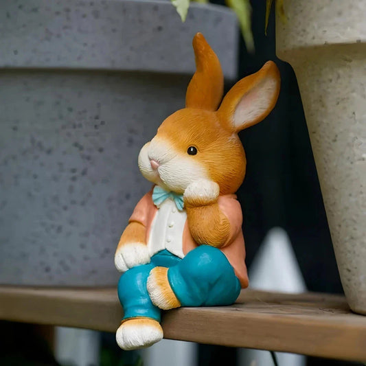 A detailed and lifelike resin statue of a thoughtfully sitting rabbit, adding a whimsical touch to any home or garden decor.