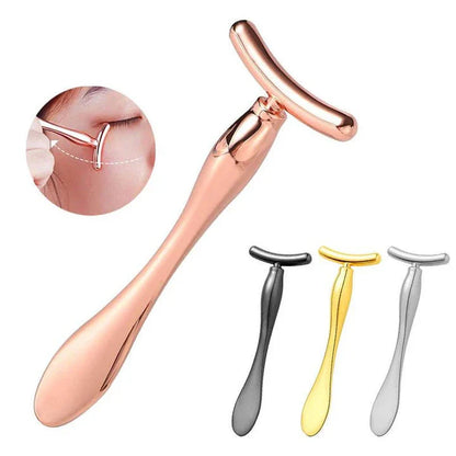 A rose gold metal eye cream applicator and face massager tool with a Y-shaped design for effective skincare application and facial massage