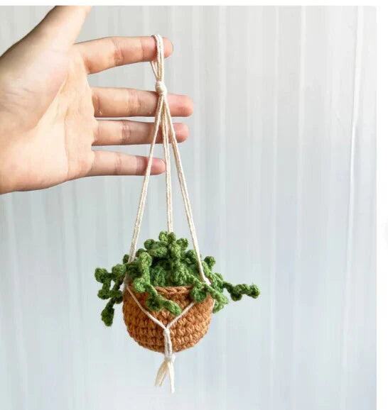 Charming knitted car plant decor with hanging white rope and green and white colour scheme