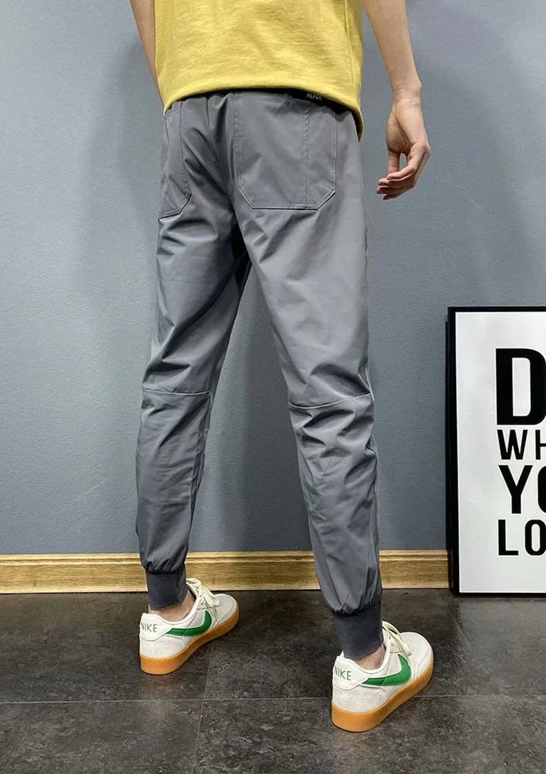 Premium slim-fit drawstring joggers in black and grey, featuring a tailored silhouette and adjustable waistband for a polished, comfortable look.