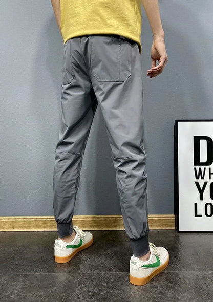 Premium slim-fit drawstring joggers in black and grey, featuring a tailored silhouette and adjustable waistband for a polished, comfortable look.