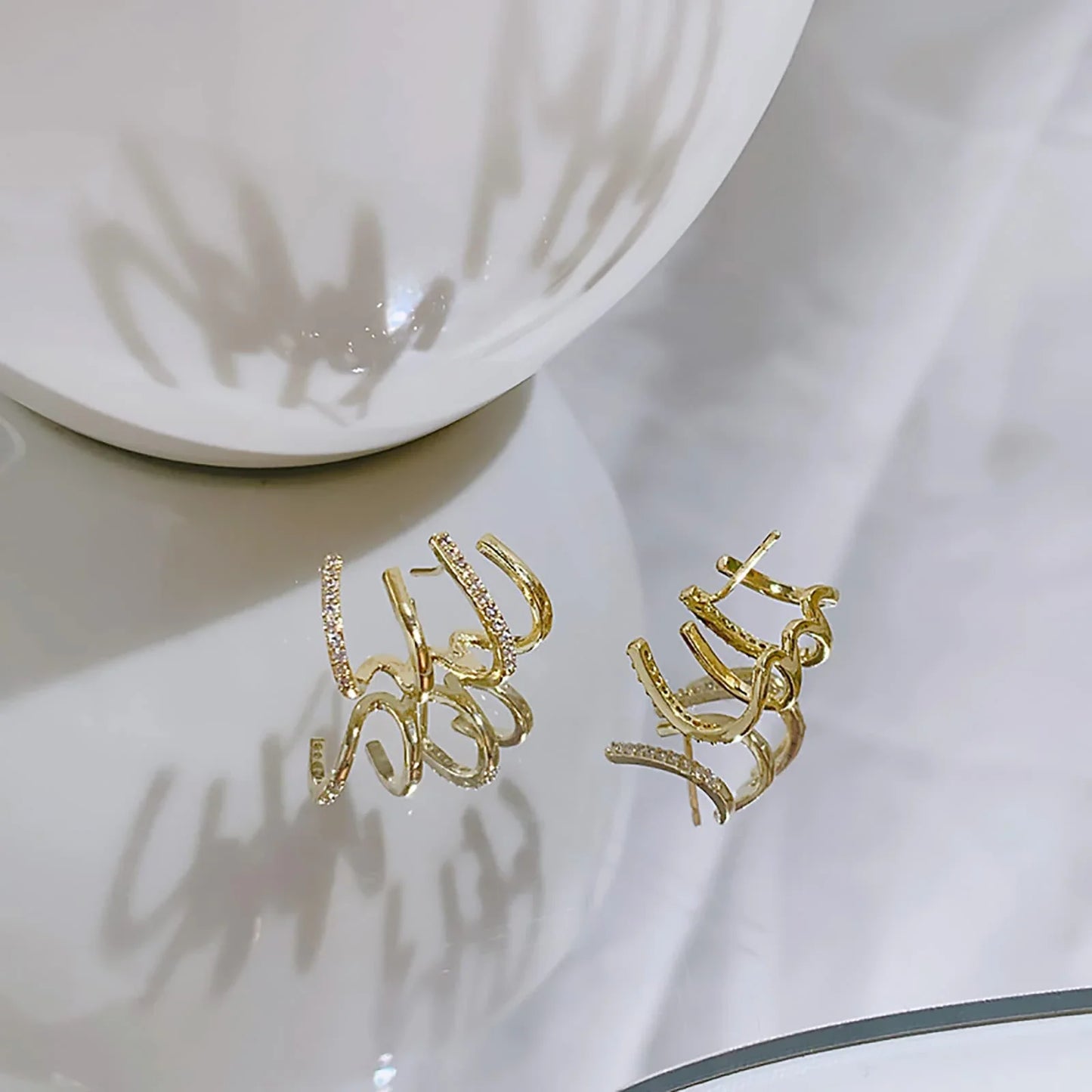 Exquisite zircon four-claw stud earrings in a gleaming gold colour, showcasing a timeless and elegant design
