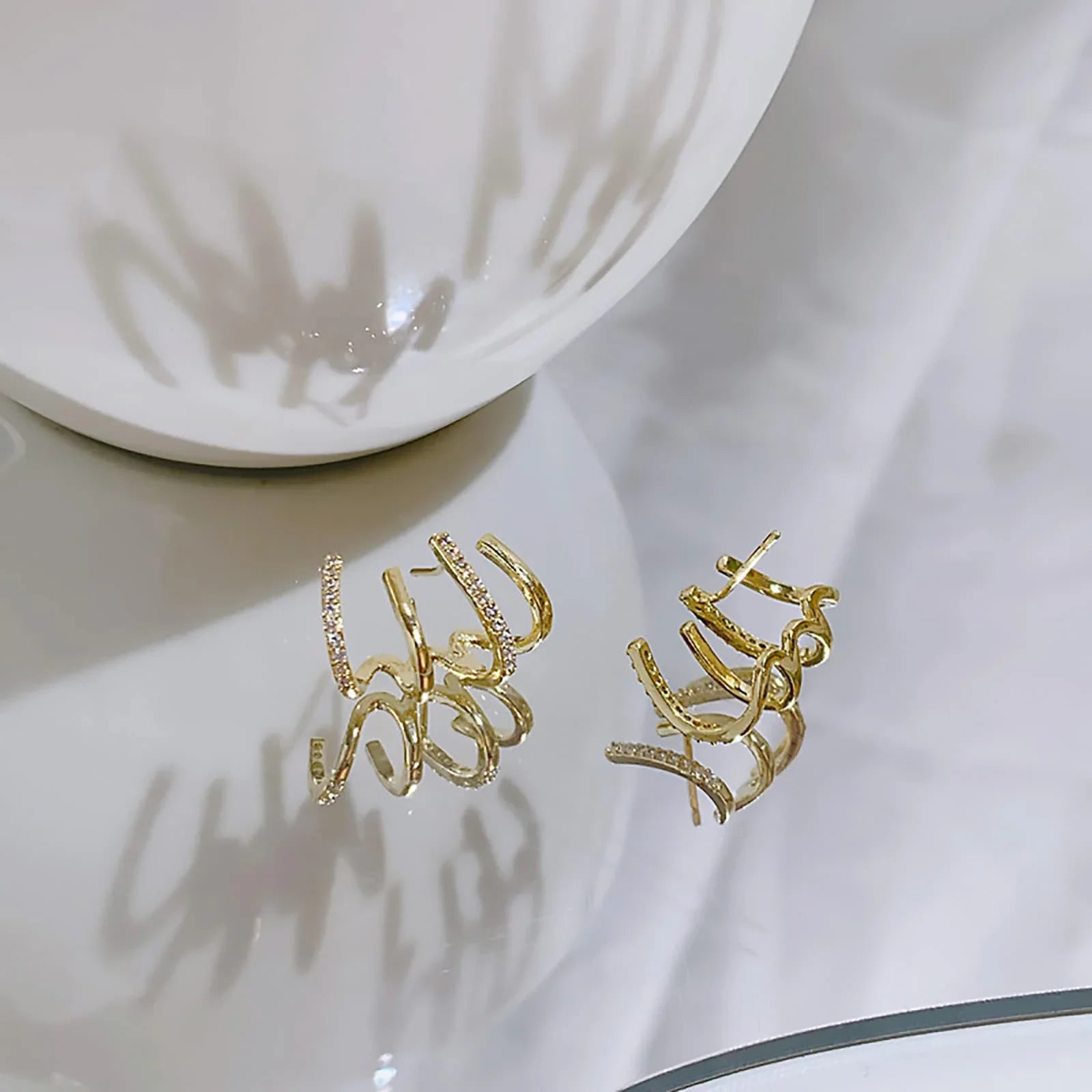 Exquisite zircon four-claw stud earrings in a gleaming gold colour, showcasing a timeless and elegant design