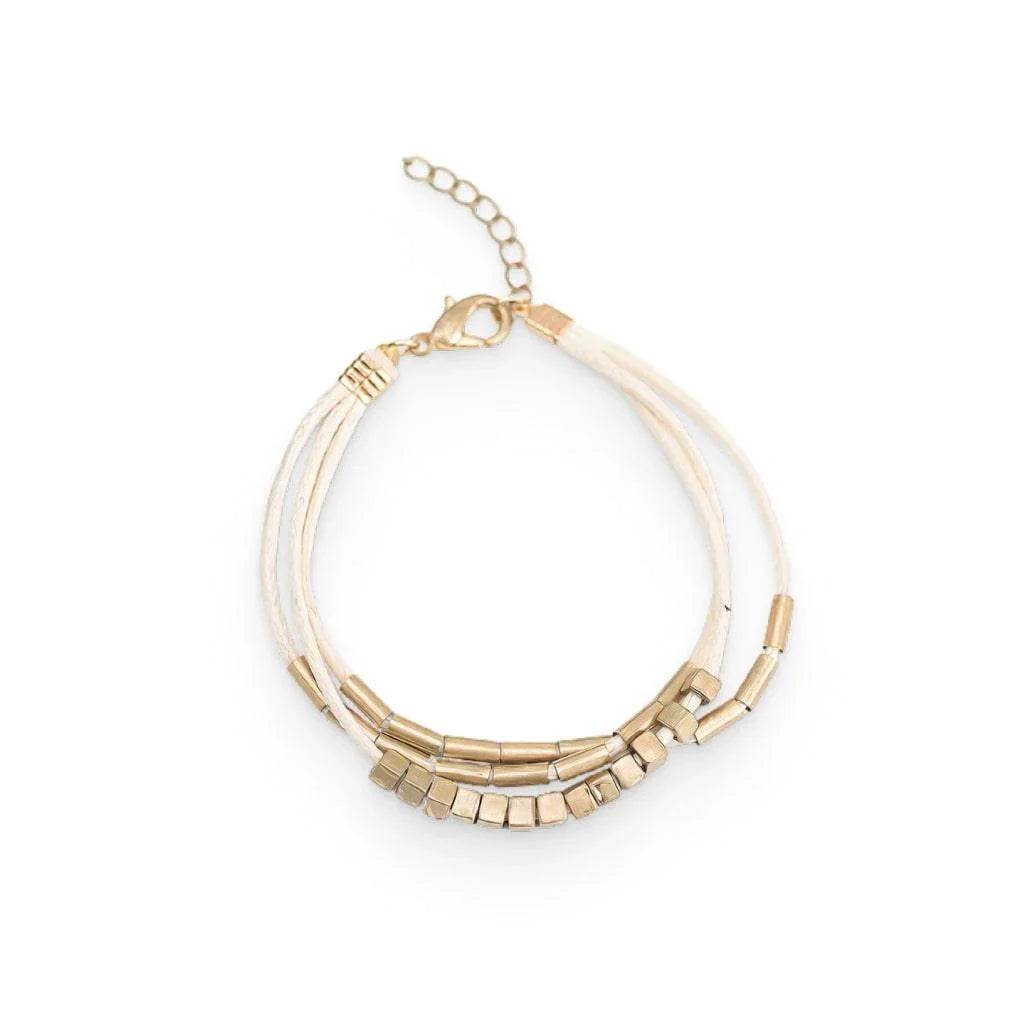 Stylish multilayered bracelet with beige leather ropes and gold-coloured beads, a modern and sophisticated accessory