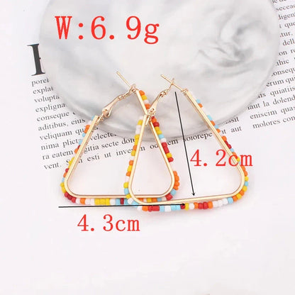 Colourful beaded triangle hoop earrings in gold metal with vibrant beadwork
