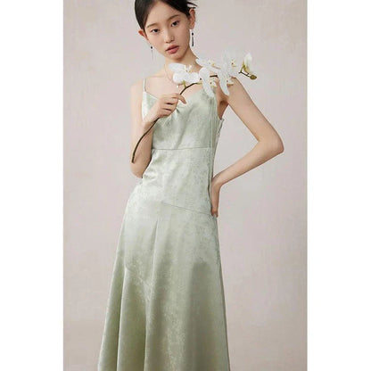 Elegant mint green midi dress with spaghetti straps, featuring a flattering slim fit and beautiful embroidery detailing