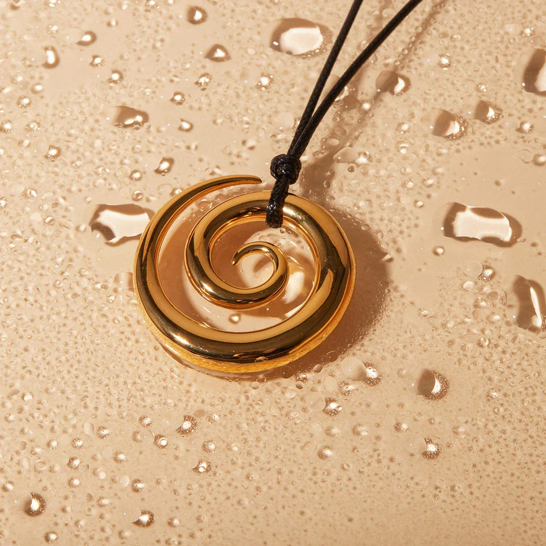 Exquisite spiral circle pendant necklace with 18K gold plating and black rope chain, a versatile accessory for the modern British woman.