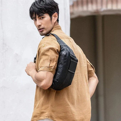 Premium cowhide messenger bag in black, featuring a spacious interior, adjustable shoulder strap, and sleek, minimalist design