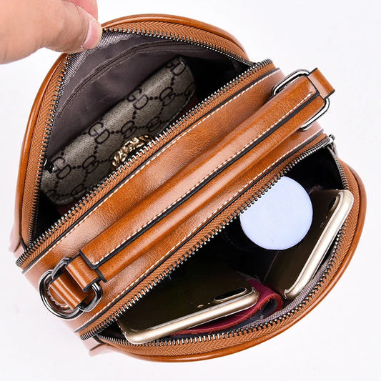 A stylish and versatile stitched shoulder bag in a classic brown colour, featuring a sleek oval shape and multiple interior compartments for organised storage.
