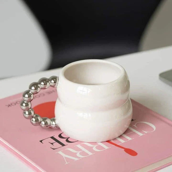 Handmade ceramic mug in beige and blue Nordic-inspired design, with a comfortable handle for enjoying hot or cold beverages.
