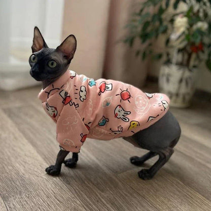 Cat wearing a colourful, printed sweatshirt in a vibrant yellow-bear design