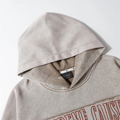 Embroidered cotton hoodie with a letter patch design, available in brown, grey, and black colours and sizes S to XL